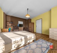 Bedroom in a 3-room apartment with wood-decor flooring, cabinets, and a TV stand.