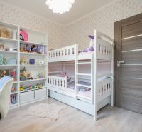 A children's room in a 3-room apartment with a bunk bed and shelves full of toys.