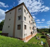 An apartment building on Kpt. Uhra in Myjava, surrounded by greenery and blue skies.