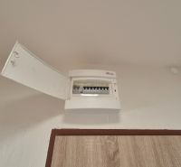 An open distribution box in a studio apartment with a view of the fuses.
