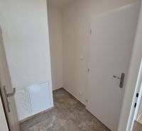 Entrance hall of a studio apartment with tiles and white doors.