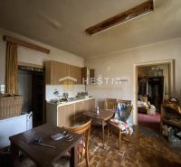 A kitchen in a family house with wooden decor flooring and a dining table.