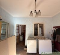 The interior of a family house with cracked plaster and older furniture.