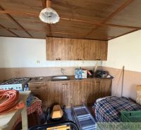 A kitchen in a family house with a wooden ceiling paneling and a gas stove.