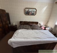 Bedroom in a family house with an antique bed and a painting on the wall.