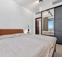 Bedroom with a large bed and a wardrobe in a two-room apartment.