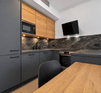 A kitchen unit in a 2-room apartment with a wooden decor floor and modern appliances.