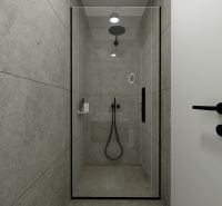 A shower corner with gray tiles and black accessories in a 2-room apartment.