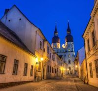 A historic alley in Trnava with a cathedral in the background, ideal for living in a 2-room apartment.