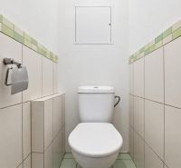 A toilet with simple tiles and light tiles in a 3-room apartment.