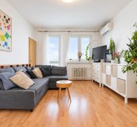 A living room in a 3-room apartment with a wooden decor floor and comfortable seating.