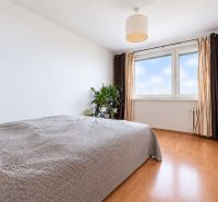 Bedroom in a 3-room apartment with a large window and a wooden decor floor.