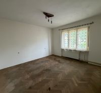 An empty room with a wood-patterned floor and a large window in a family house.