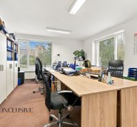 Offices with wood-decor flooring, a large desk, and cabinets full of documents.