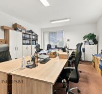 Offices with wood-patterned flooring, desks, chairs, and boxes full of documents.