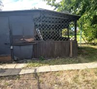 Garden shelter in Nesvady surrounded by greenery and a paved path in the Gardens.