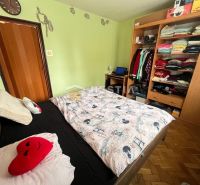 Bedroom with a built-in wardrobe, Paris-themed bedding, and a wooden decor floor.