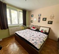 Bedroom with a bed and decorations in a 3-room apartment, floor with wooden decor.