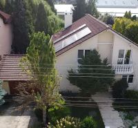 A family house in Trenčianske Stankovce surrounded by greenery, with solar panels on the roof.