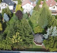 Family houses in Trenčianske Stankovce surrounded by dense greenery and colorful trees.