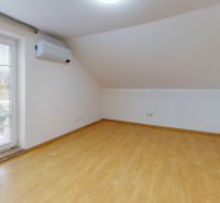 Attic room in a family house with a wooden decor floor and air conditioning.