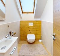 A bathroom in a family house with a wooden decor floor and a skylight.