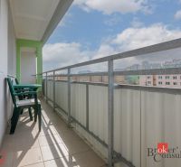 A balcony with plastic furniture and a view of apartment buildings in Bratislava-Karlova Ves on Donnerova.