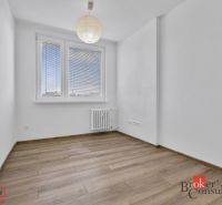 A bright room with wood-patterned flooring, a window, and a radiator in a 5+ room apartment.