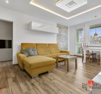 A living room in a 5 or more room apartment with a wood-patterned floor and a yellow sofa.