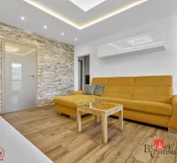 A living room with a wood-patterned floor and a yellow sofa in a 5 or more room apartment.