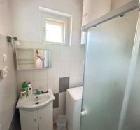 Bathroom in a family house with a sink, shower, and washing machine.