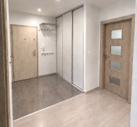 Interior of a 3-room apartment with a wooden decor floor and a built-in wardrobe.