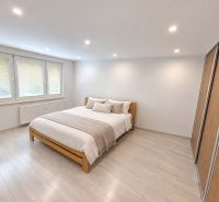 Bedroom in a 3-room apartment with a bed, wardrobe, and floor with a wooden decor.