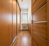 A hallway with a built-in wardrobe and a floor with a wooden decor in a 3-room apartment.