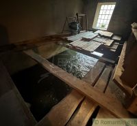 Interior of a family house with flowing water and wooden boards on the floor.