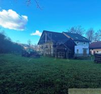 A family house in Mokrá Lúka with a tractor on a spacious garden surrounded by nature.