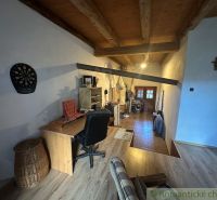 Attic office in a family house with a wooden decor floor and a wooden ceiling.