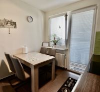 Kitchen in a 3-room apartment with a dining table and chairs, light decoration.