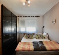 Bedroom with a bed, built-in wardrobe, and a window in a 3-room apartment.