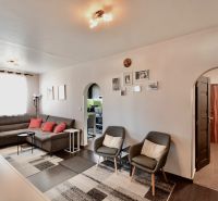 Living room in a 3-room apartment with a wooden decor floor and a comfortable sofa set.