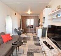 Living room in a 3-room apartment with a comfortable sofa, armchairs, and storage space.
