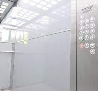 Interior of an elevator with a lit ceiling and a panel with buttons for a 3-bedroom apartment.