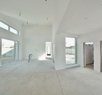 The interior of a family house with large windows and light walls.