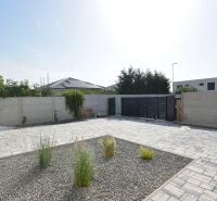 The courtyard of a family house on Kráľovianky in Šamorín with paving and greenery.