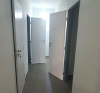 A hallway with multiple doors and tiles in a 3-room apartment.