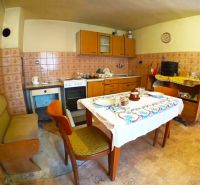 A kitchen in a family house with classic furniture and patterned tiles.