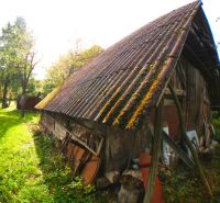 An older wooden building with a metal roof in the garden of a family house in Buková.