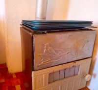 Wood-burning stove with a metal chimney in a family house, floor with a wooden decor.