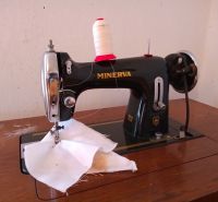 A Minerva sewing machine on a wooden table in a family house.