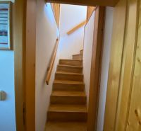 Stairs with a wooden decor in a holiday apartment leading to the upper floor.
